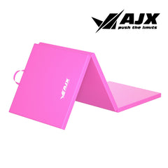 A pink yoga mat with a motivational quote printed on it, placed in a bright and airy gym