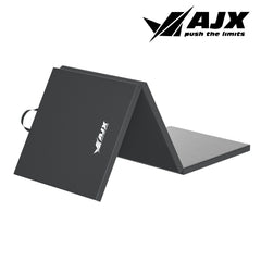 A simple black yoga mat laid flat on a wooden floor, with a subtle texture visible on its surface, ready for practice