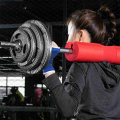 Color-coded Olympic weight plates arranged on a barbell in a well-equipped fitness studio, ready for lifting